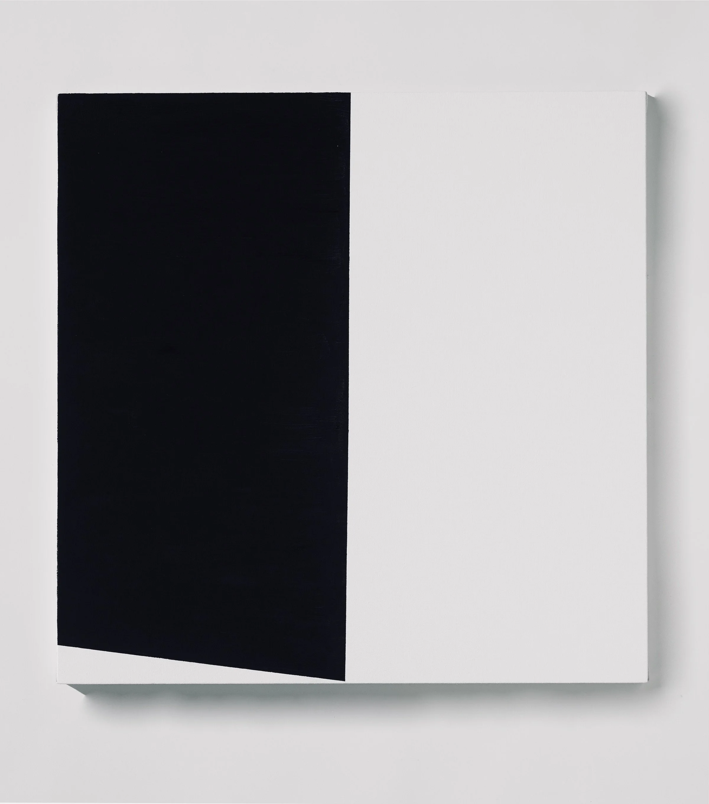 Close-up of a black and white abstract painting on a white wall.