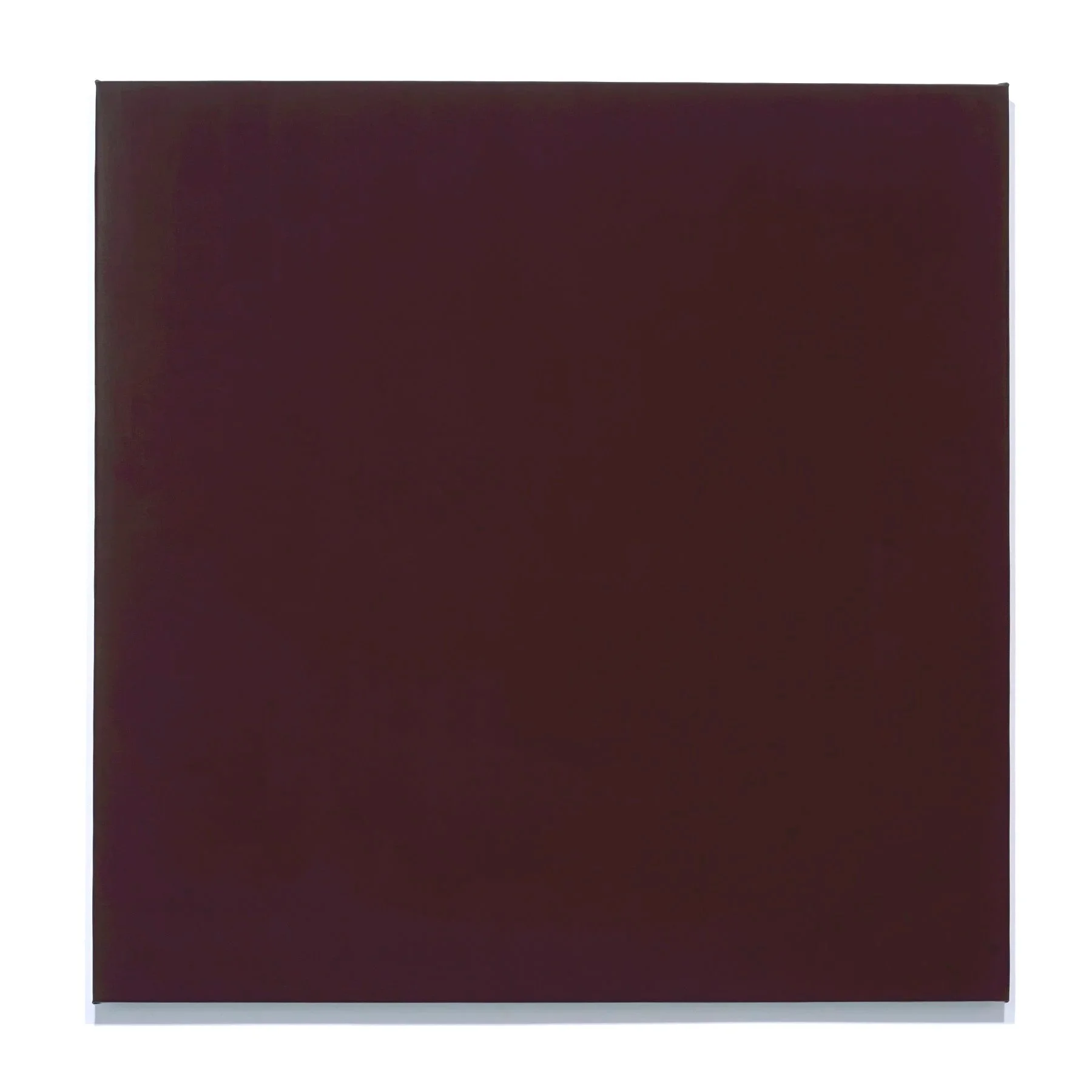Close-up of a dark maroon, almost black, square surface with a matte finish and slightly rounded edges, isolated on a white background.