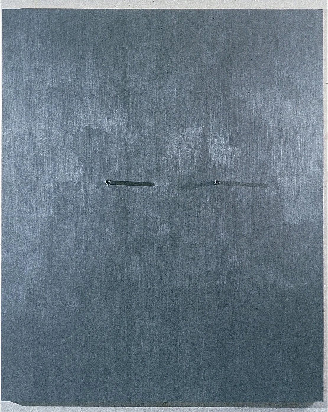 A plain wall with two small door hinges connected by a thin metal rod, creating a minimalistic and industrial appearance.