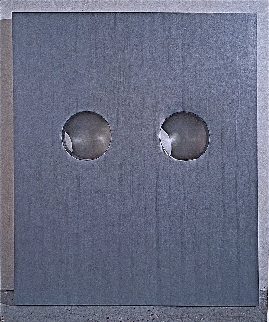 A metallic door with two circular cutouts.