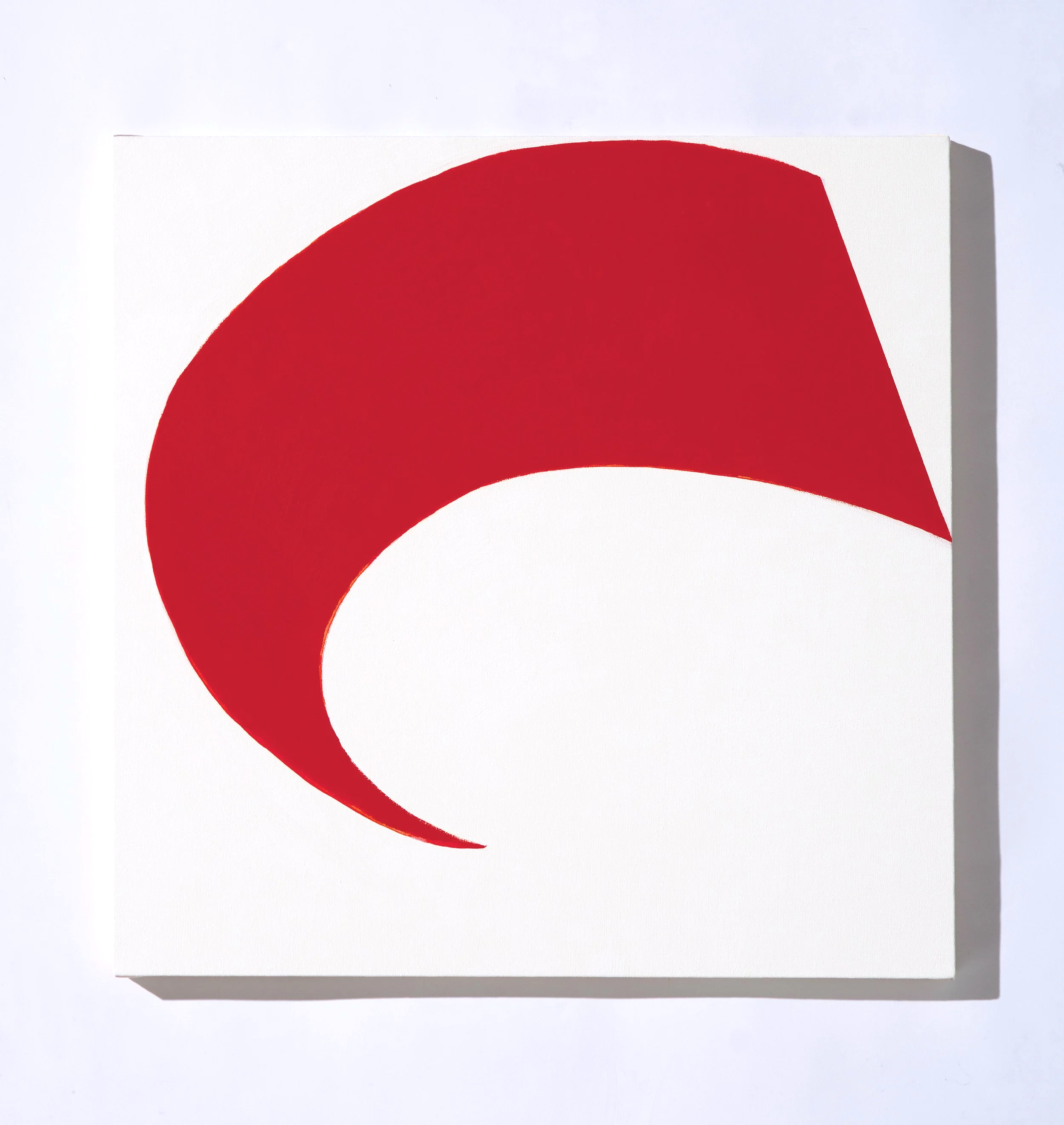 Close-up of a minimalist white canvas with a red semi-circular shape on it.