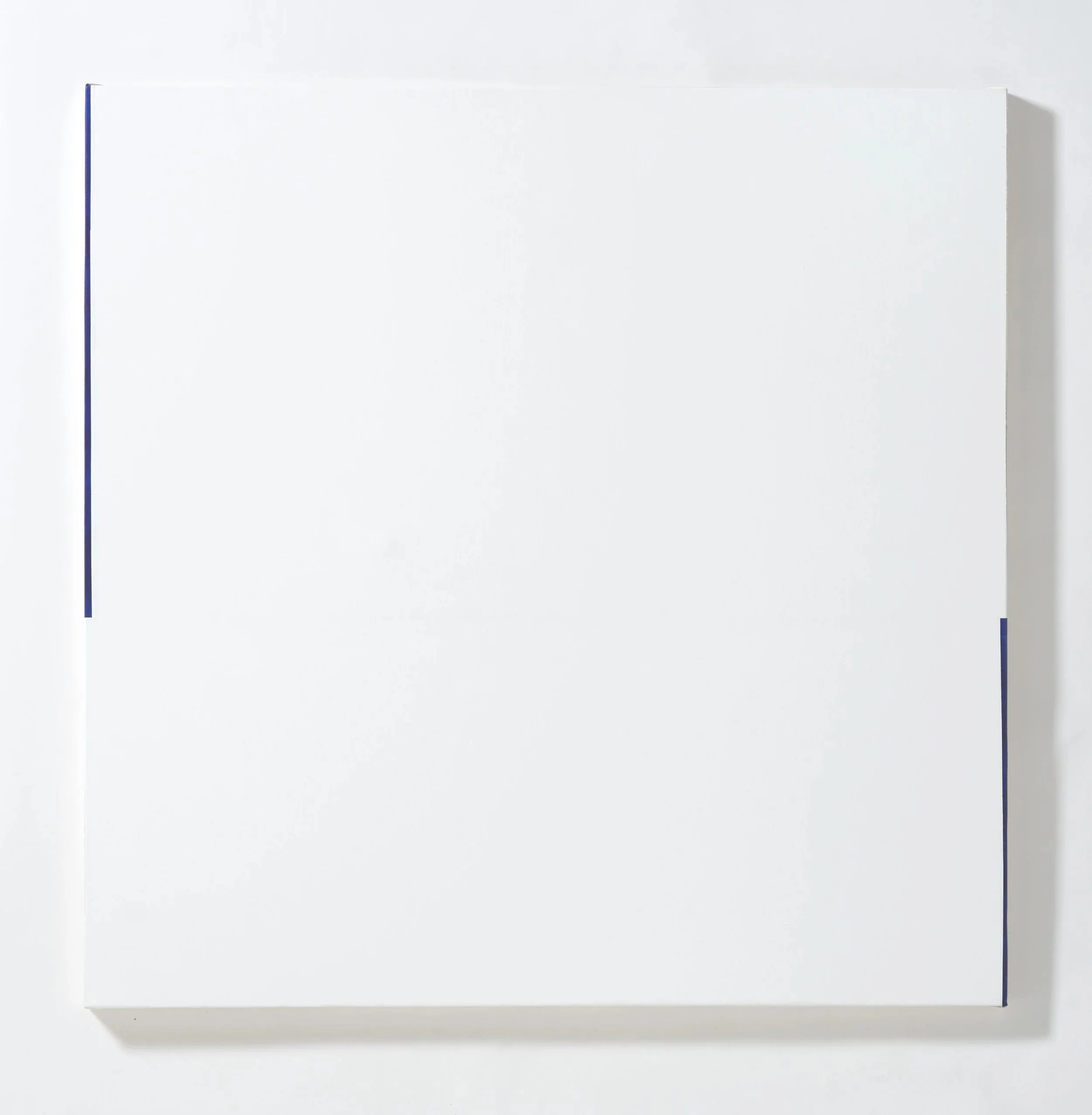 White magnetic dry erase board mounted on a wall with metal frame, no writing on it.