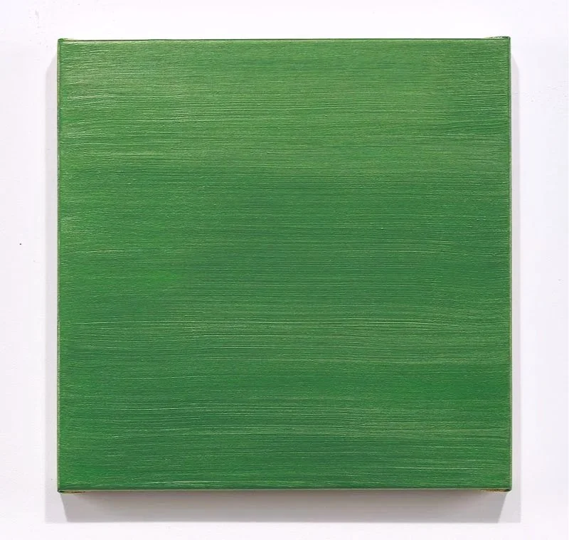 Green textured square canvas or artwork on a white wall.