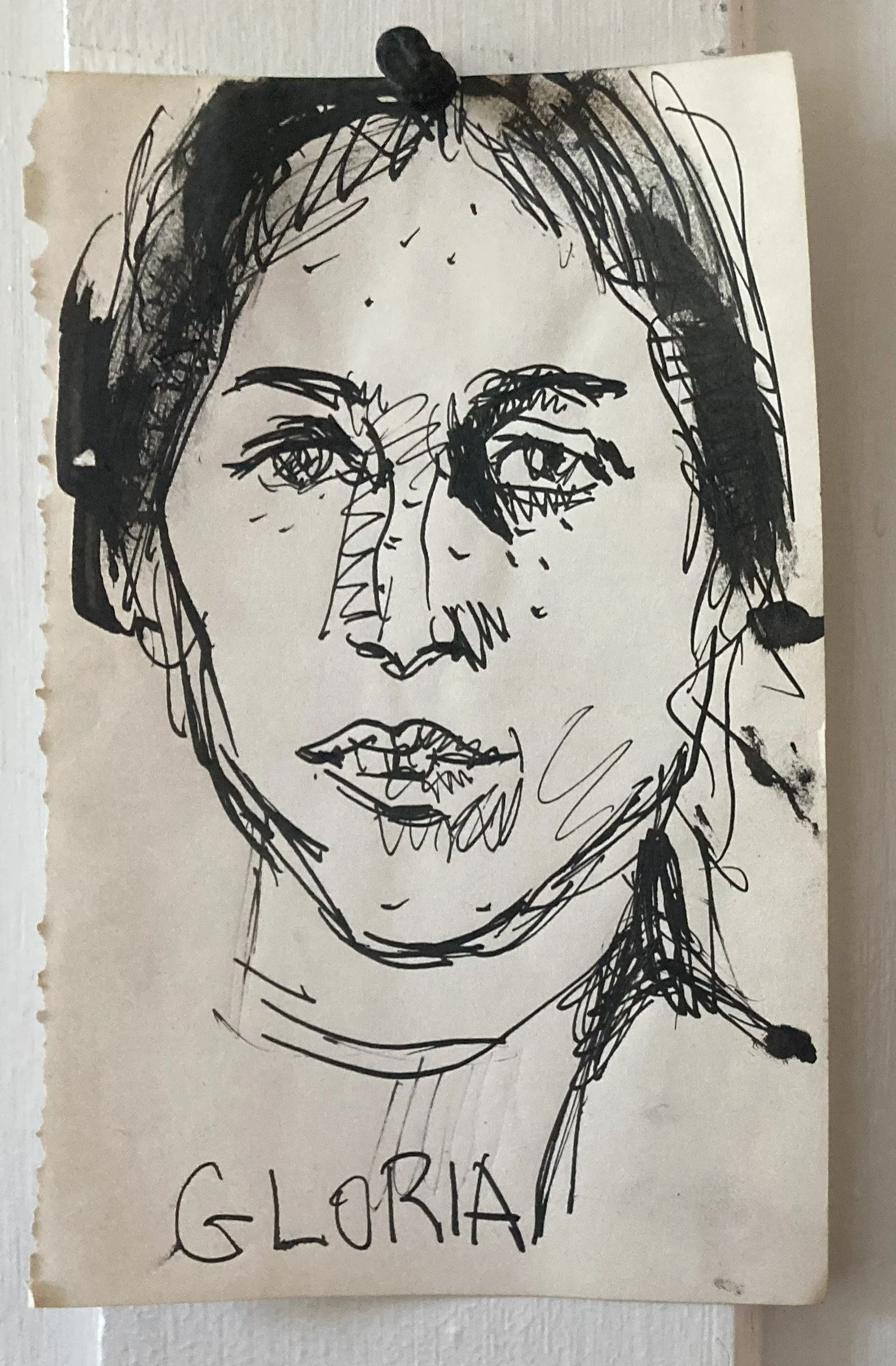 Black ink sketch of a woman's face with the words 'GLORIA' written below.