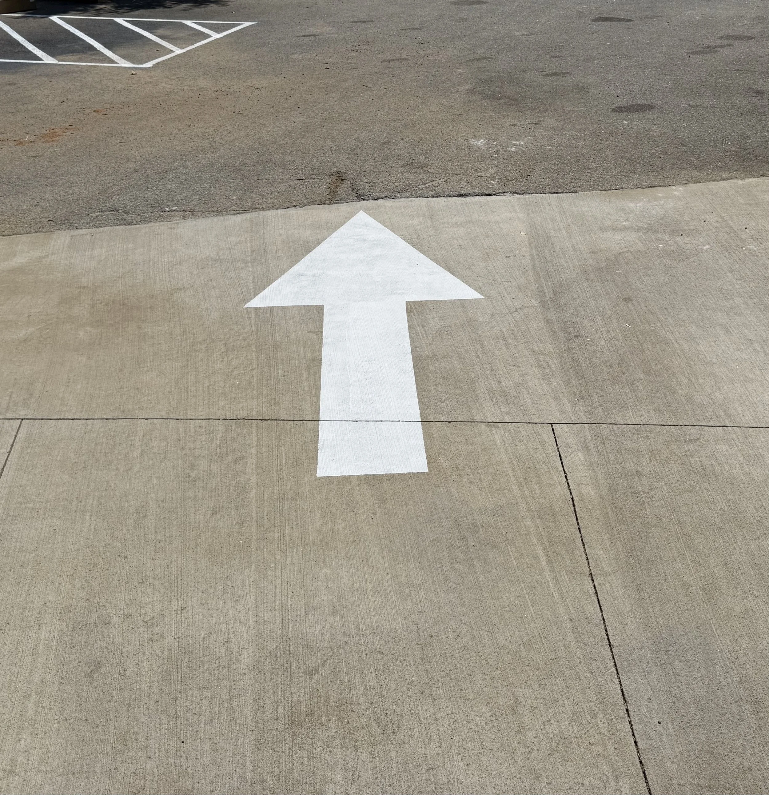 White directional arrow pavement marking in Northwest Arkansas