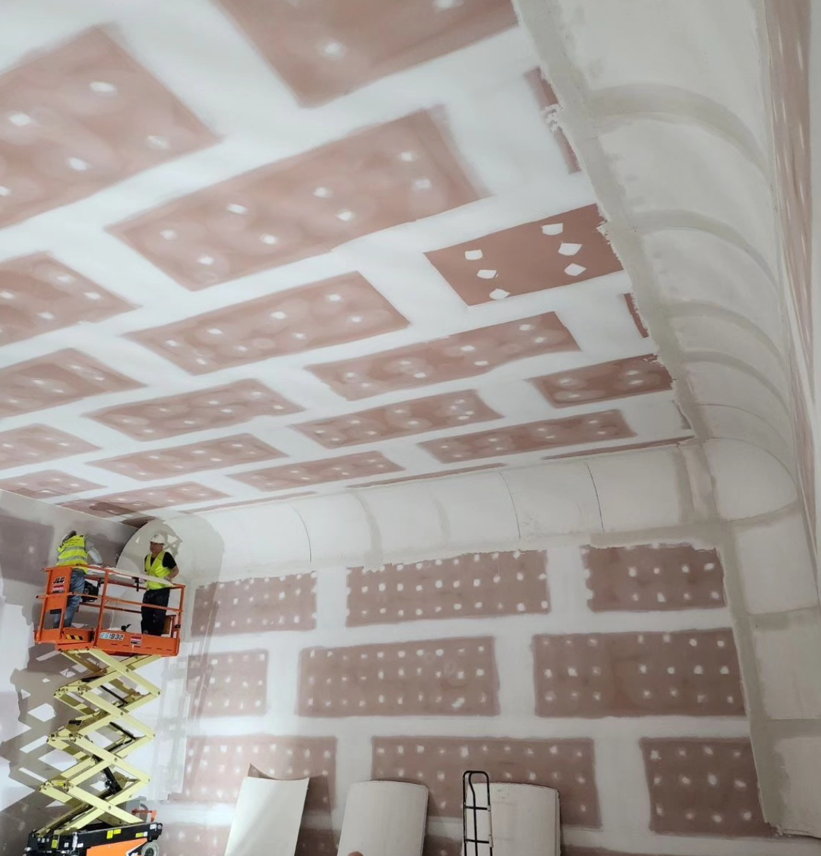 Film studio cyclorama wall installation in progress using scissor lift — Covingsmith