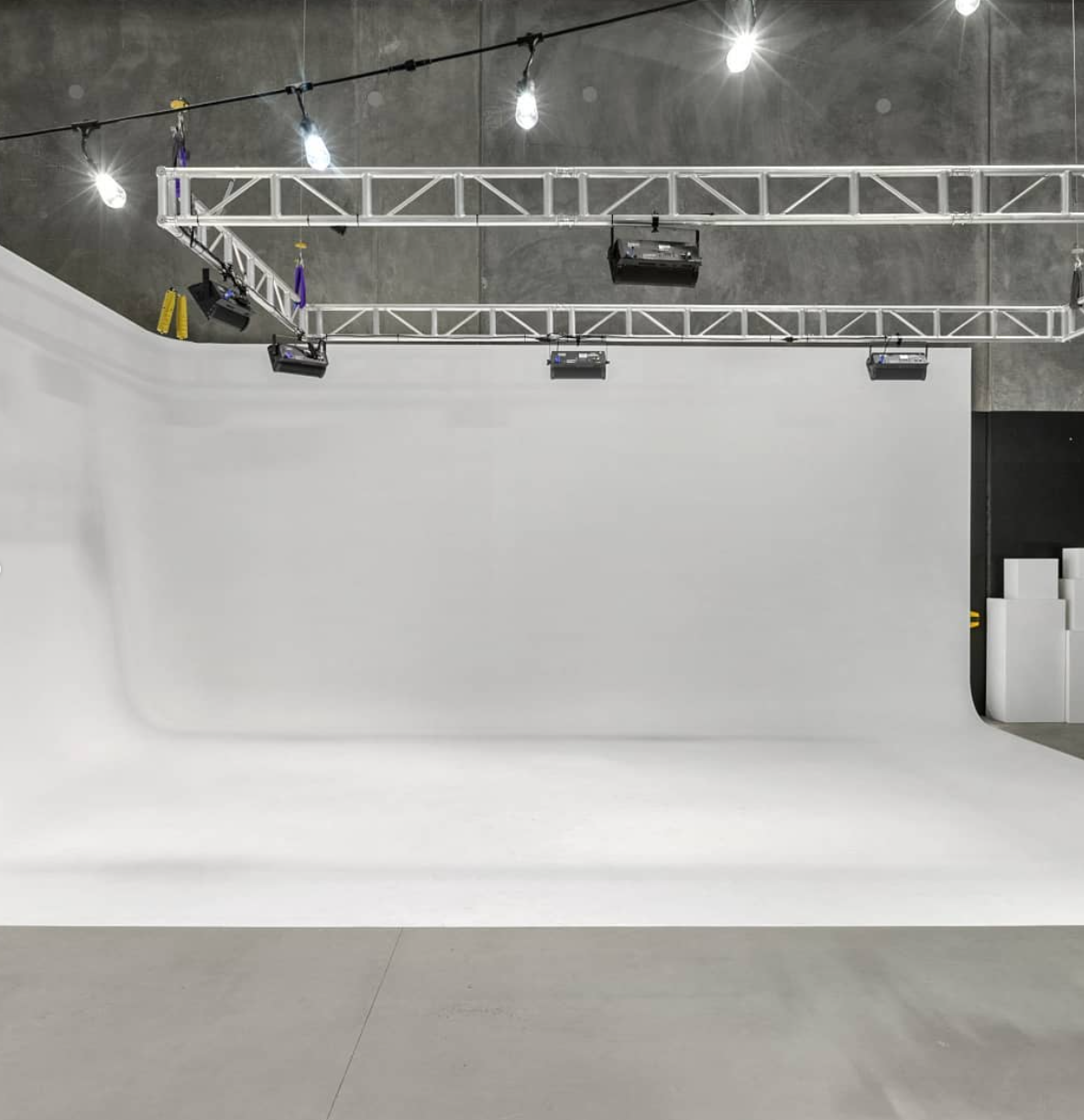 Cyclorama studio with overhead lighting truss and curved wall