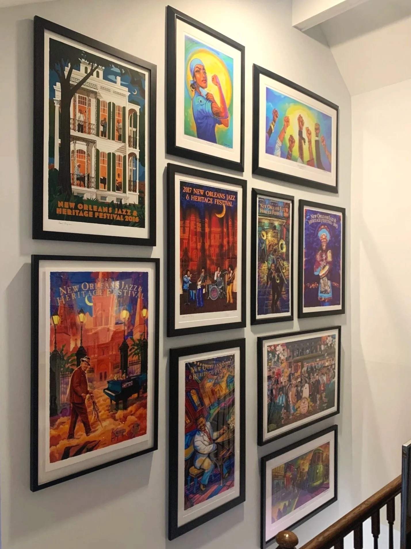 A collection of posters on a wall showcasing the New Orleans Jazz & Heritage Festival, including artwork featuring musicians, festival scenes, and promotional posters.