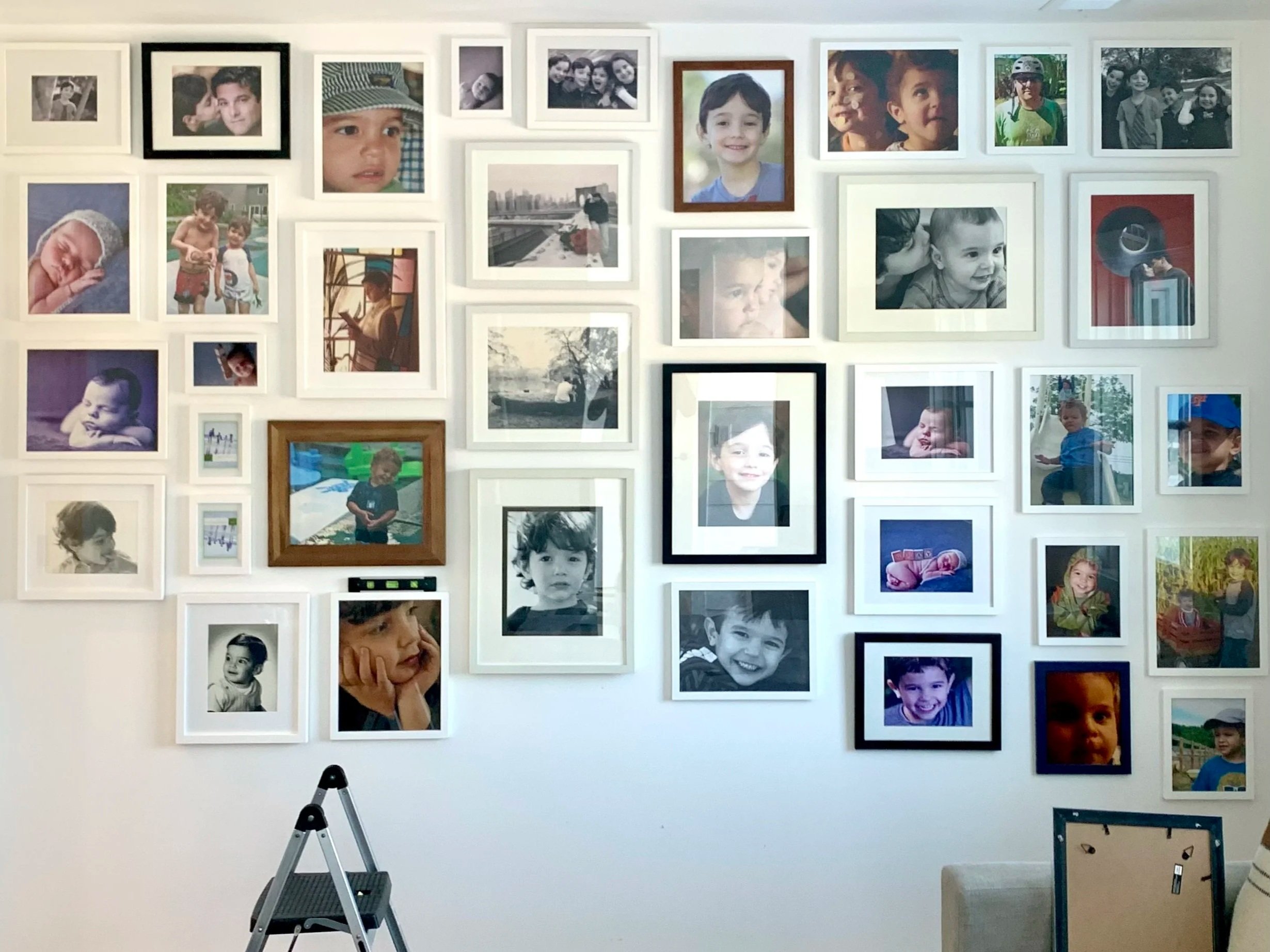 A beautifully decorated wall with multiple framed family photographs.