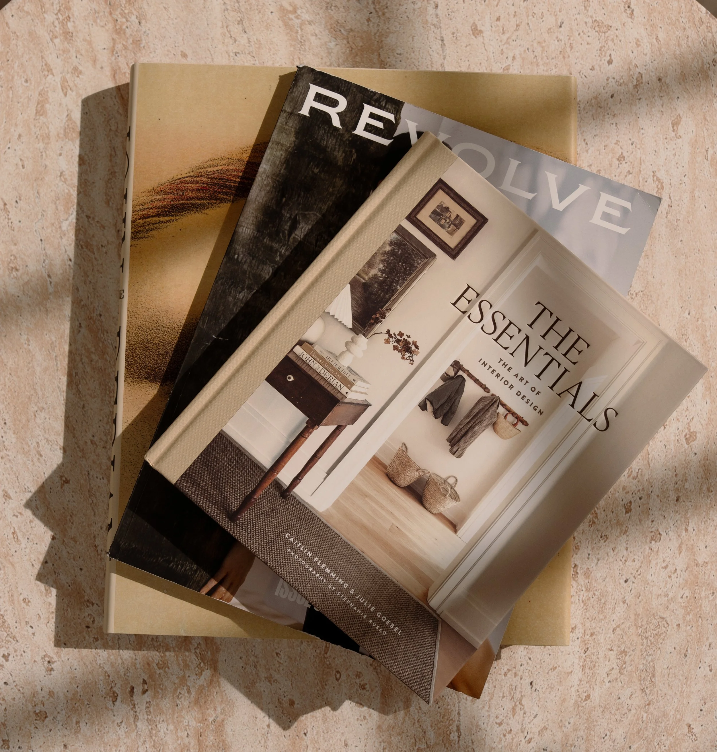 Pile of coffee table books on travertine coffee table
