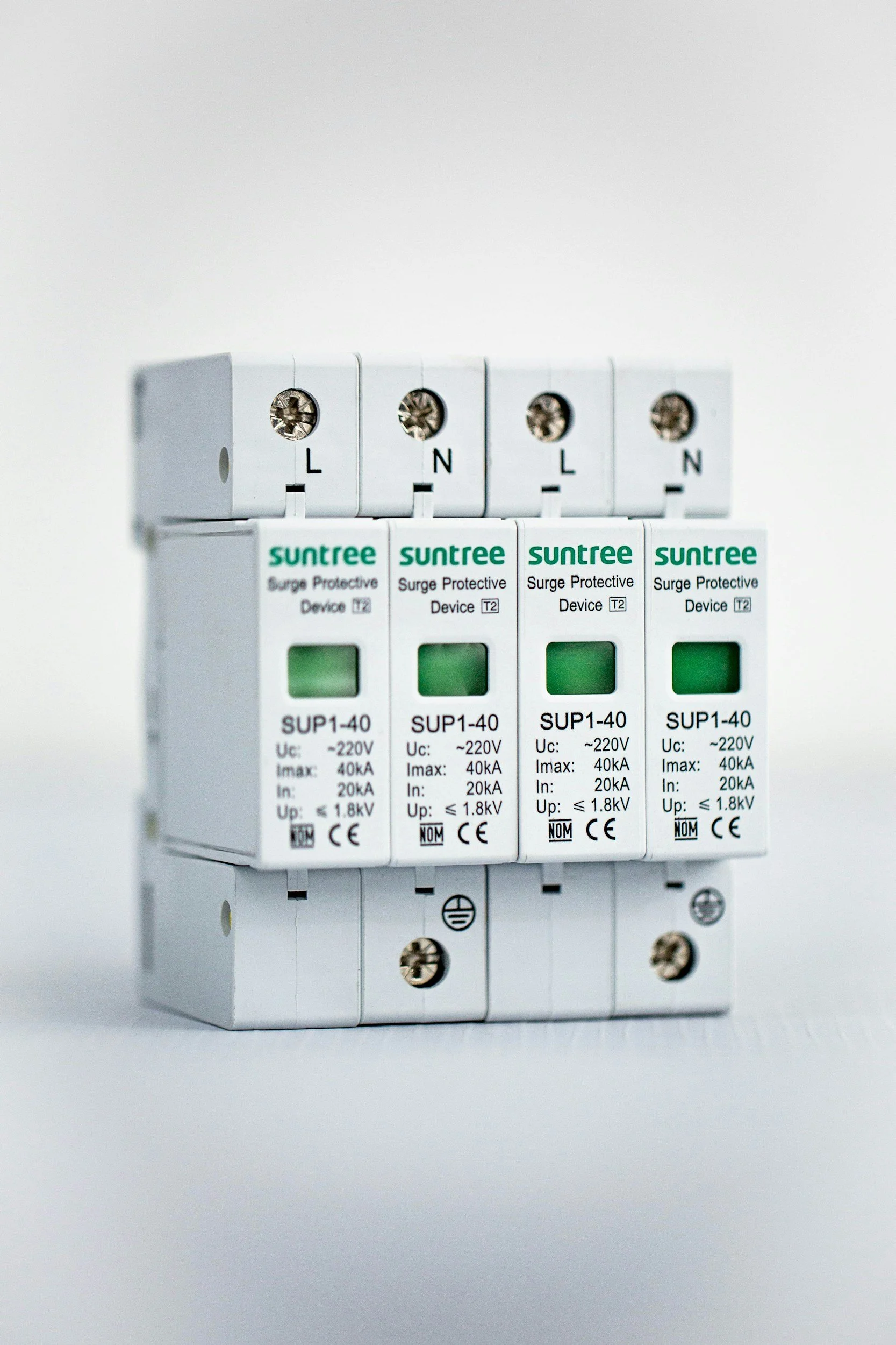 Close-up of four white surge protective devices mounted on a wall, with green indicator windows and labeling including 'Suntree' and technical specifications.