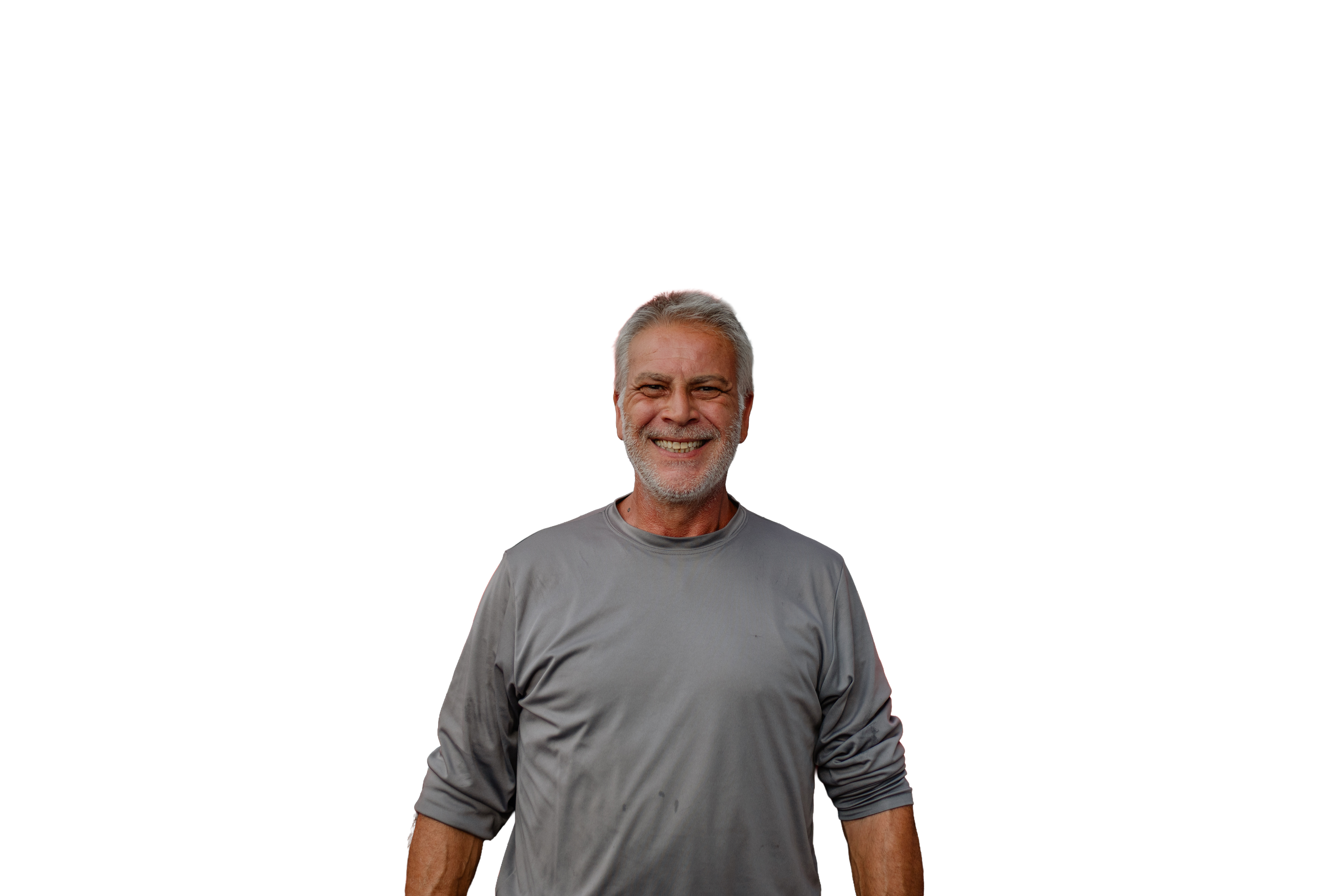 A smiling middle-aged man with gray hair and beard, wearing a gray long-sleeve shirt, standing against a plain background.