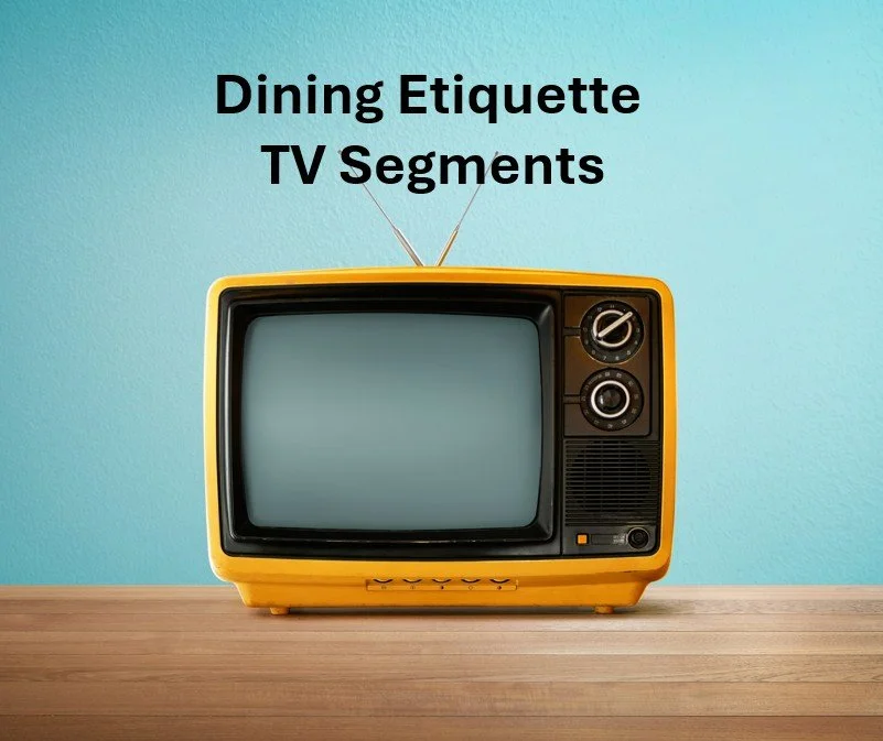 A retro yellow television set on a wooden surface with a blue wall background, with black text reading 'Dining Etiquette TV Segments' above it.