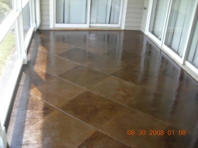 Photo of a sunroom with large glass windows and a newly stained wooden floor.