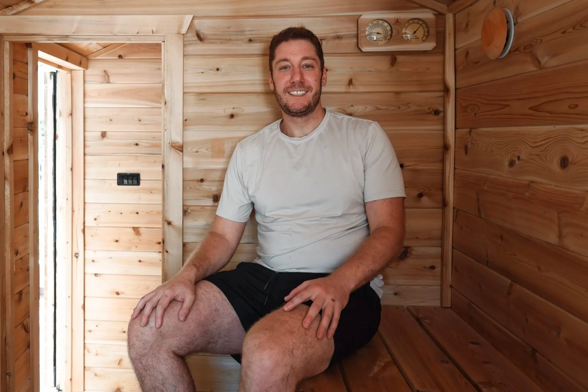 Founder Max Borg sitting inside one of The Sauna Standard’s wood-fired mobile saunas.