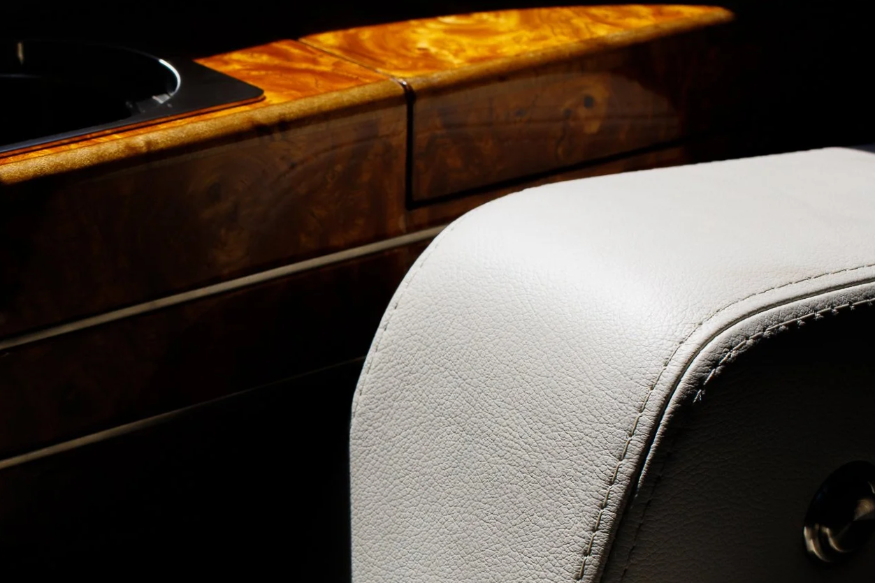 Close-up detail of a private jet interior seat and wood trim.