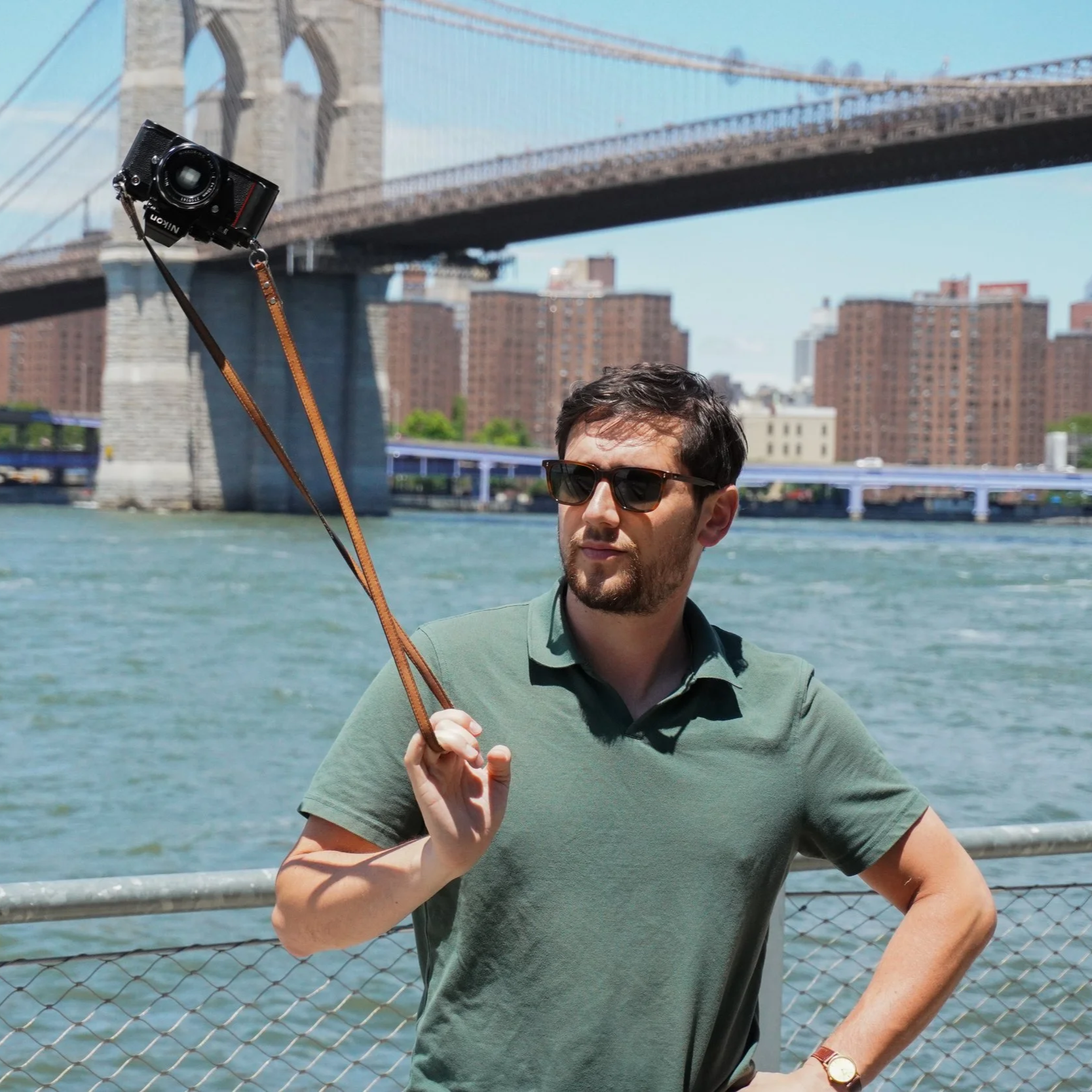 Eric Haber holding a camera near the Brooklyn Bridge.