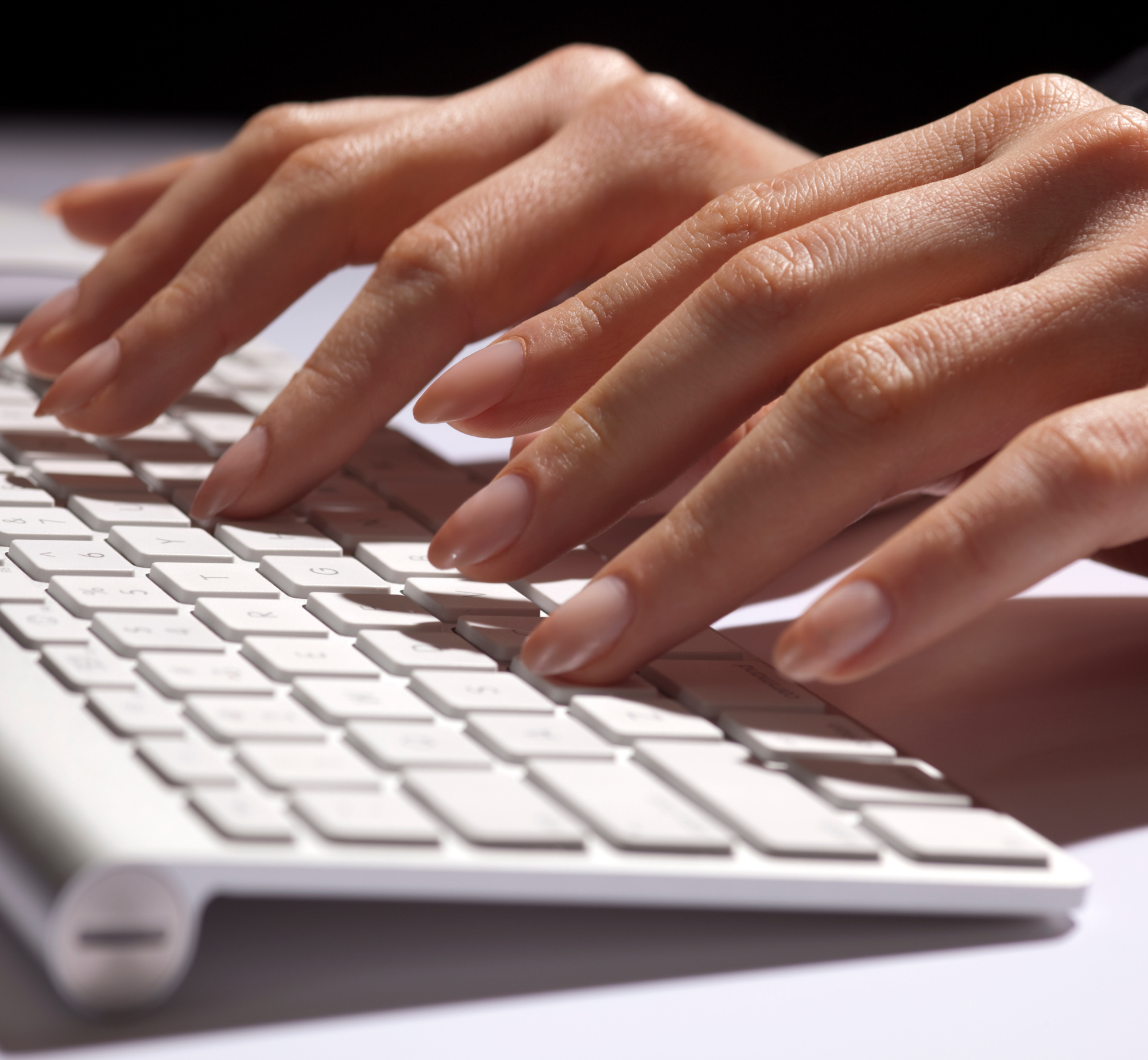 Close-up of a person's hands typing, representing applying to work with Donna Robinson Esq. LL.M.
