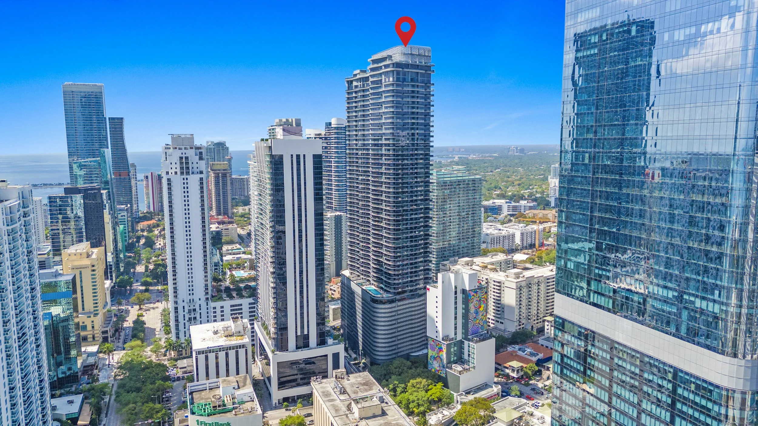 Cityscape with numerous high-rise buildings in a downtown area under a clear blue sky.