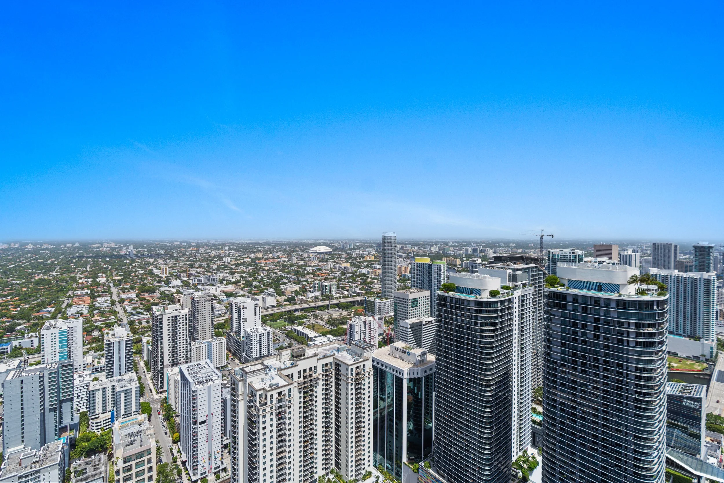 Aerial view of a modern city skyline with high-rise buildings, skyscrapers, and a clear blue sky.