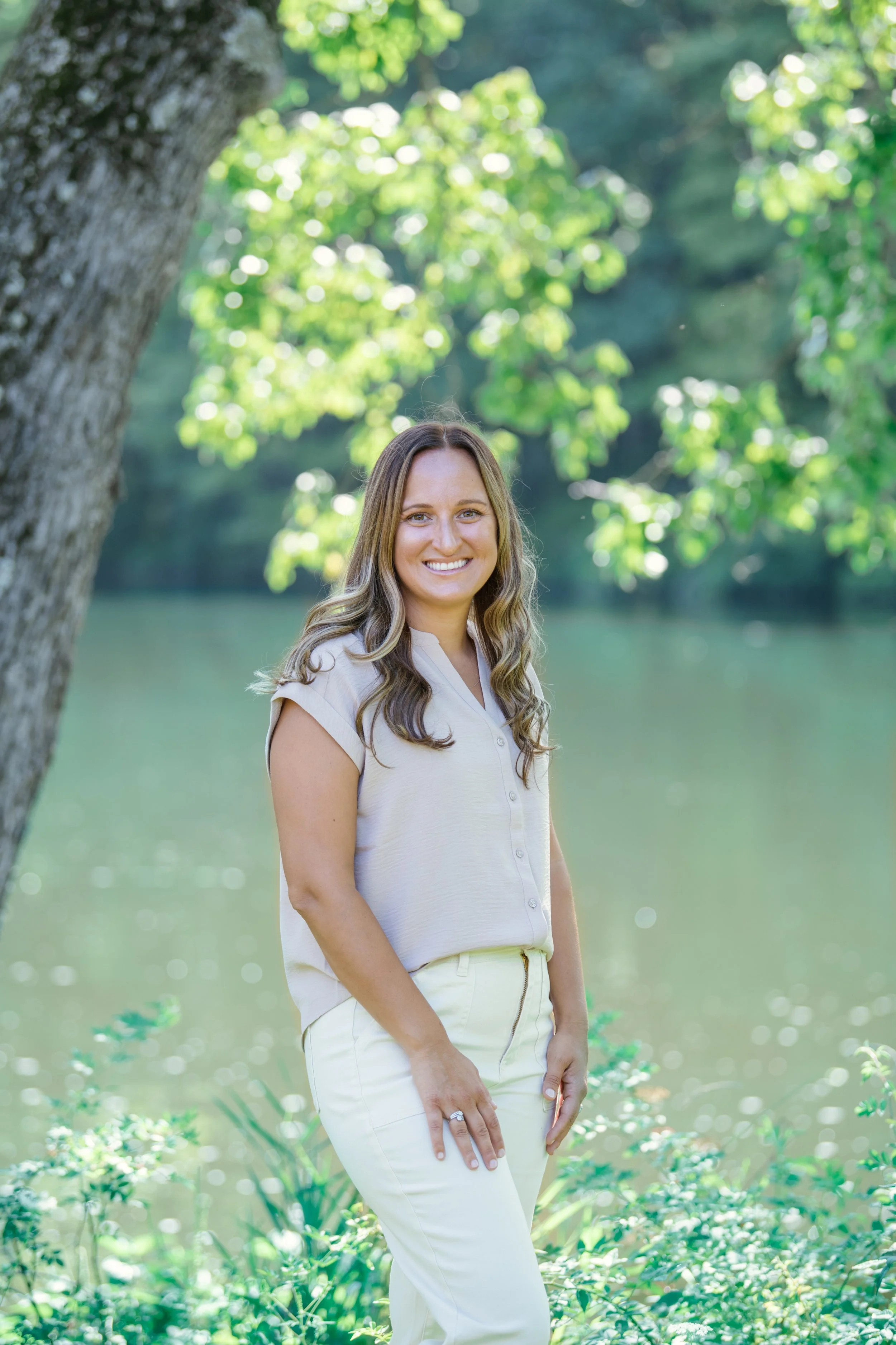 Melissa Parrish, LPC, smiling with a blurred water and tree background