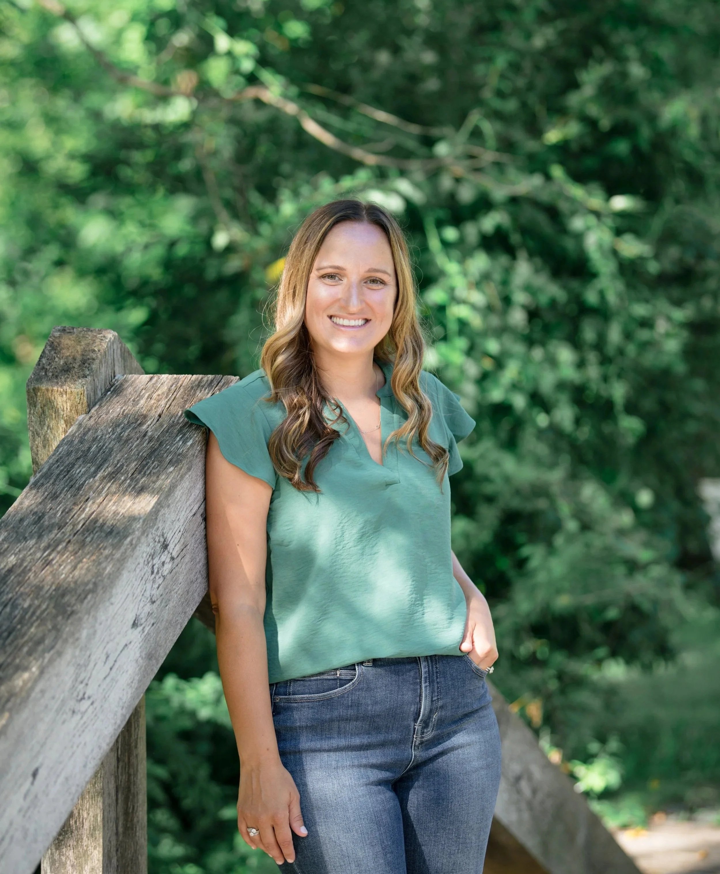 Melissa Parrish, LPC, standing on a wooden bridge surrounded by trees, Hackettstown NJ therapist