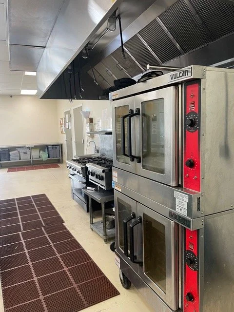 Commercial kitchen cooking line with gas ranges and ovens