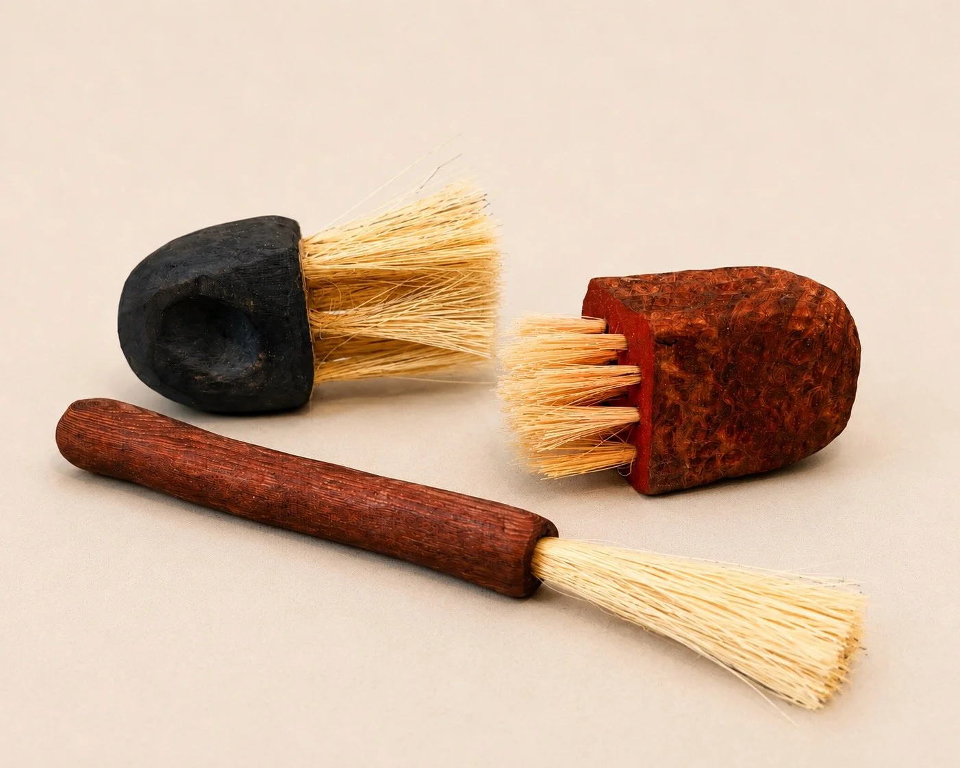 Three hand-carved wooden brushes with natural fiber bristles