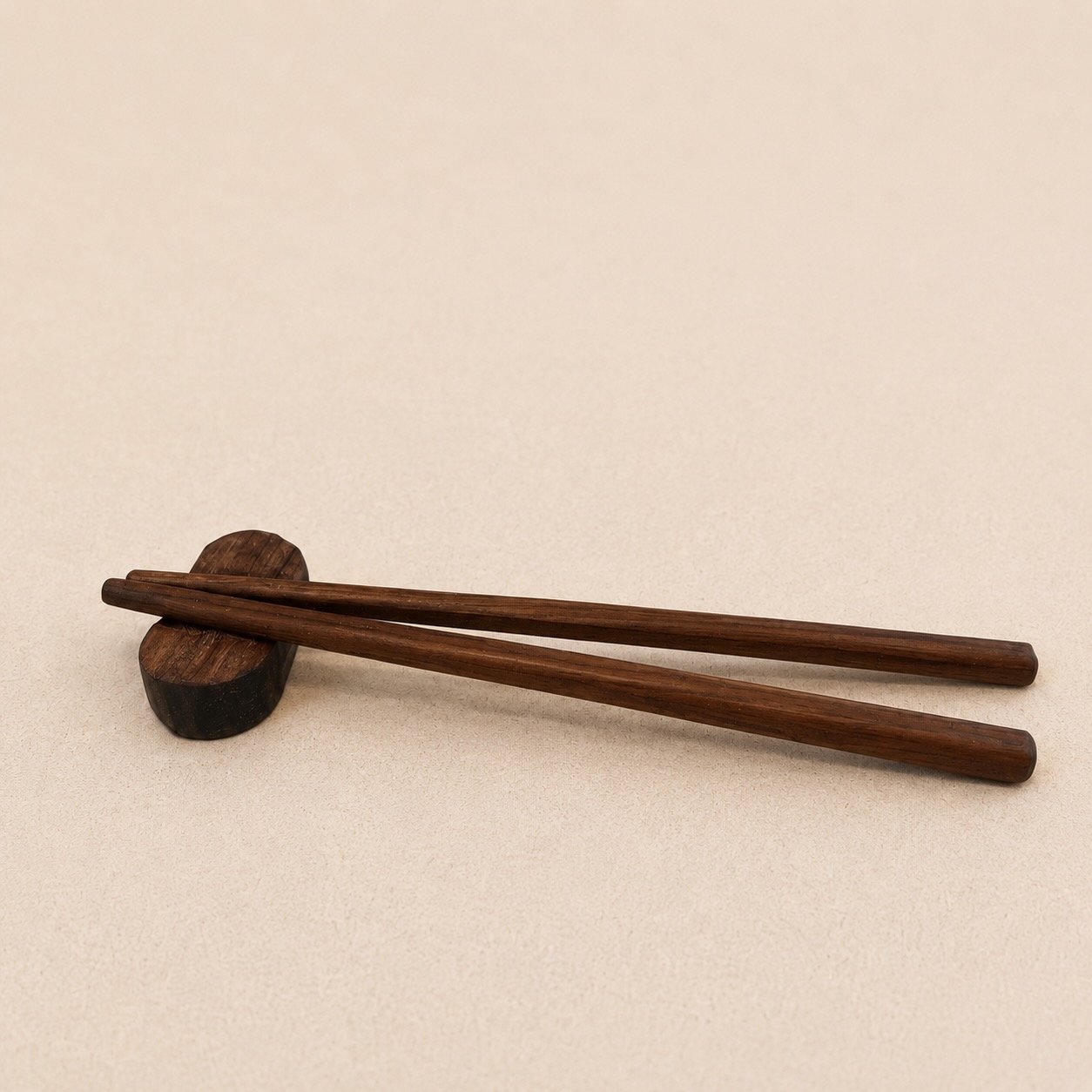 Hand-carved wooden chopsticks resting on a small sculpted holder