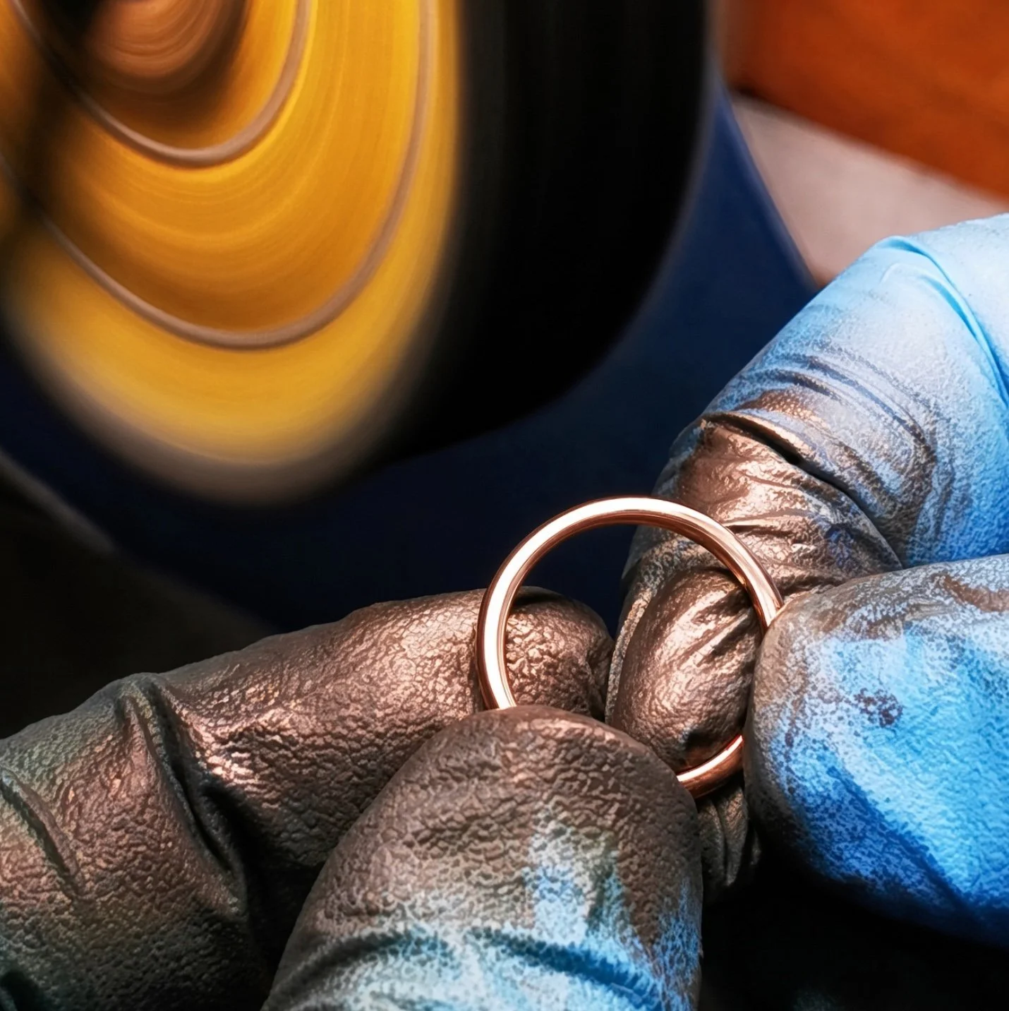 14k rose gold plain band being polished by goldsmith close up.