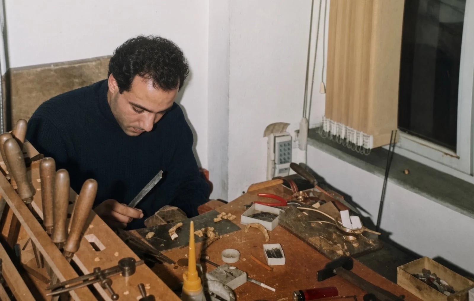 Goldsmith at a jewelry workbench in Istanbul, hand tools arranged beside the bench.