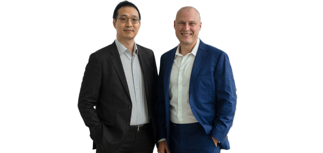 Two men in business attire standing side by side and smiling