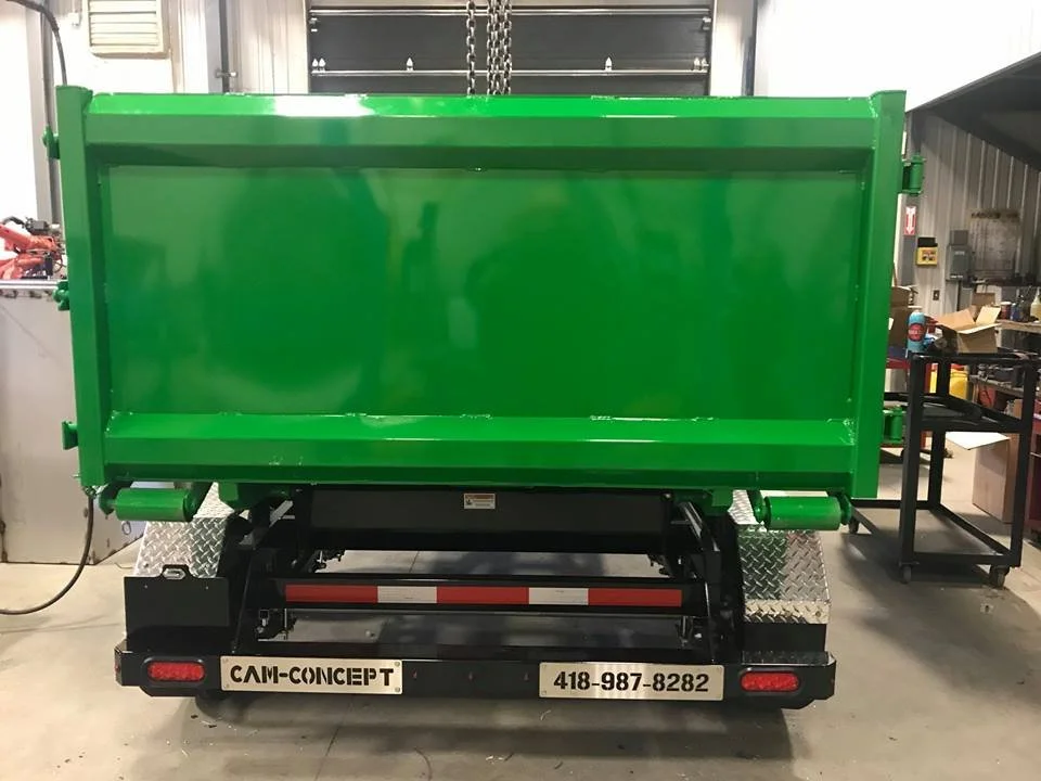 Green dump trailer with black chassis in workshop