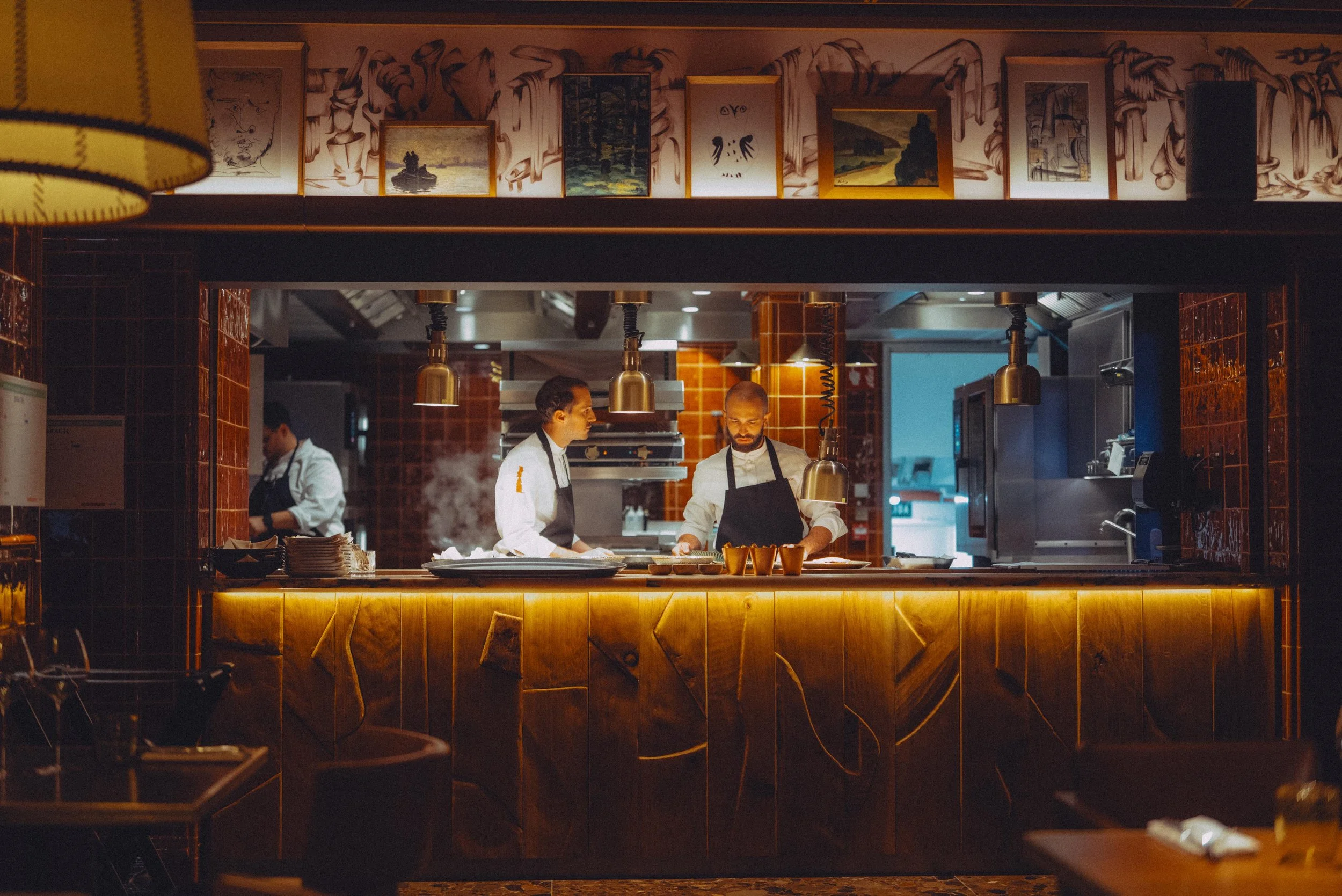 Two chefs cooking food in a restaurant kitchen
