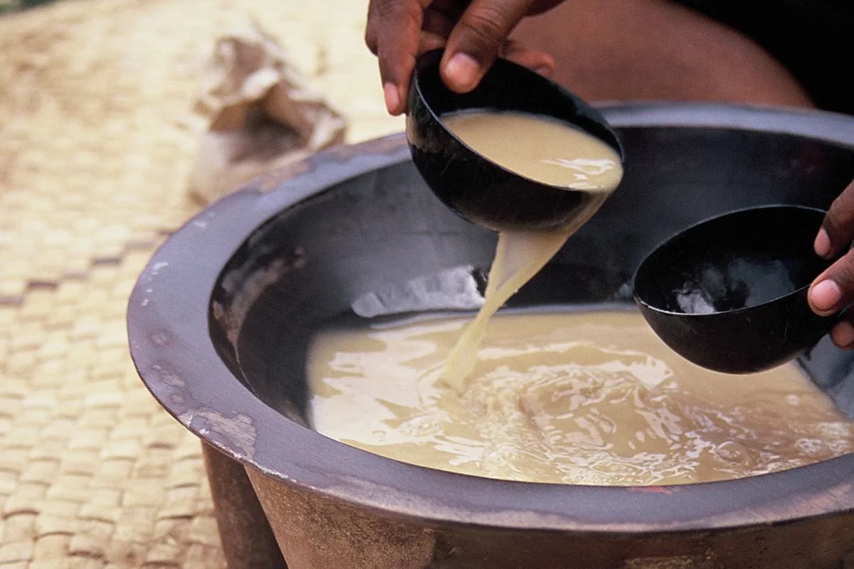 Hands pouring kava into a small traditional kava cup