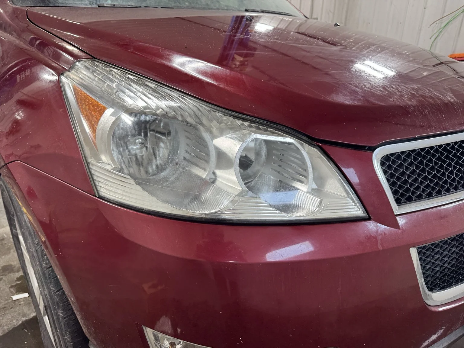 After restoration: clearer exterior lens on the same red Chevrolet headlight.