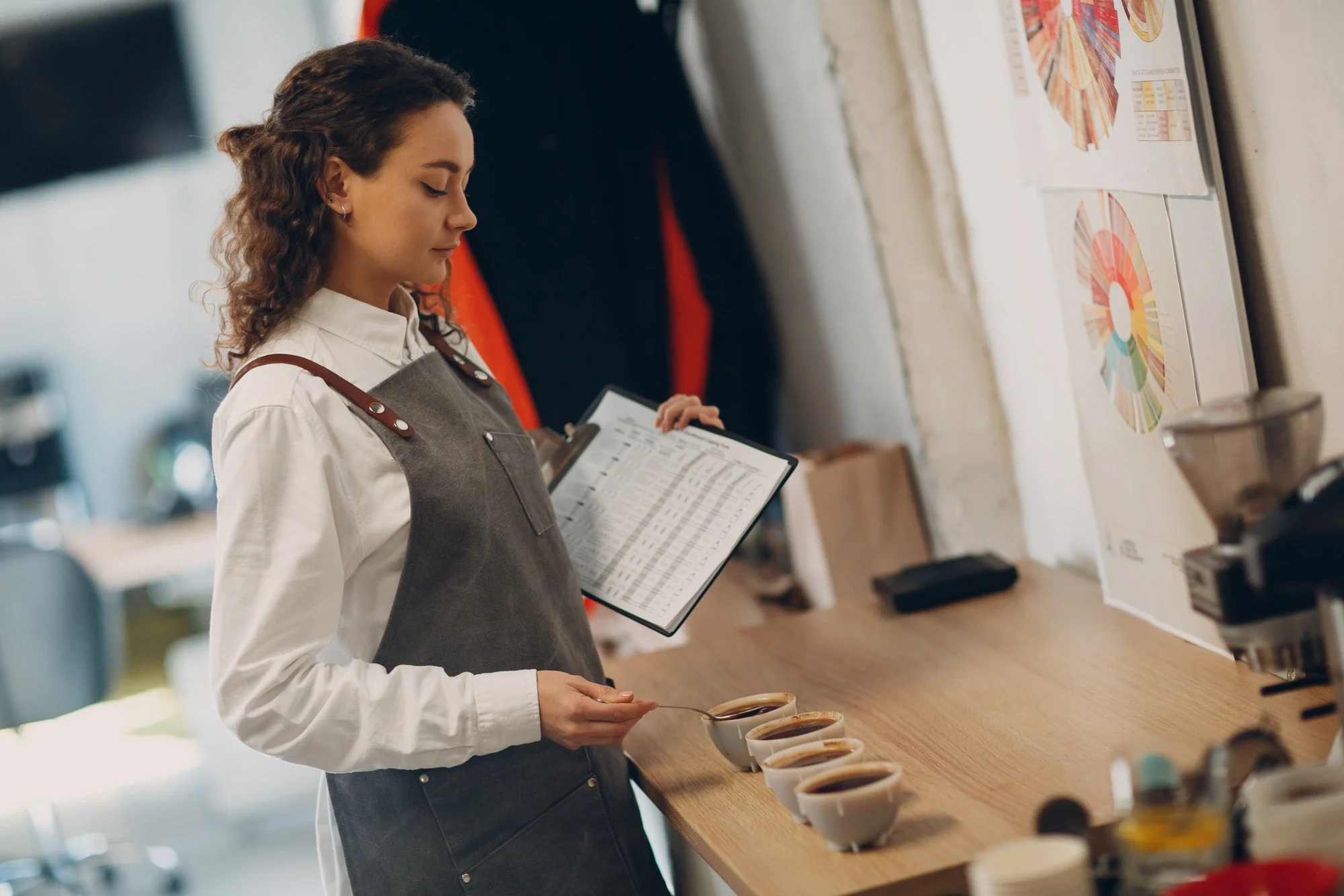 Female business owner checking stock with a clipboard, representing the ambitious entrepreneurs and growing businesses Bonehead Design helps through branding.