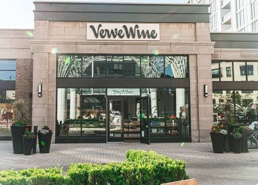 Exterior view of a VeveWne store with glass doors and plants outside.