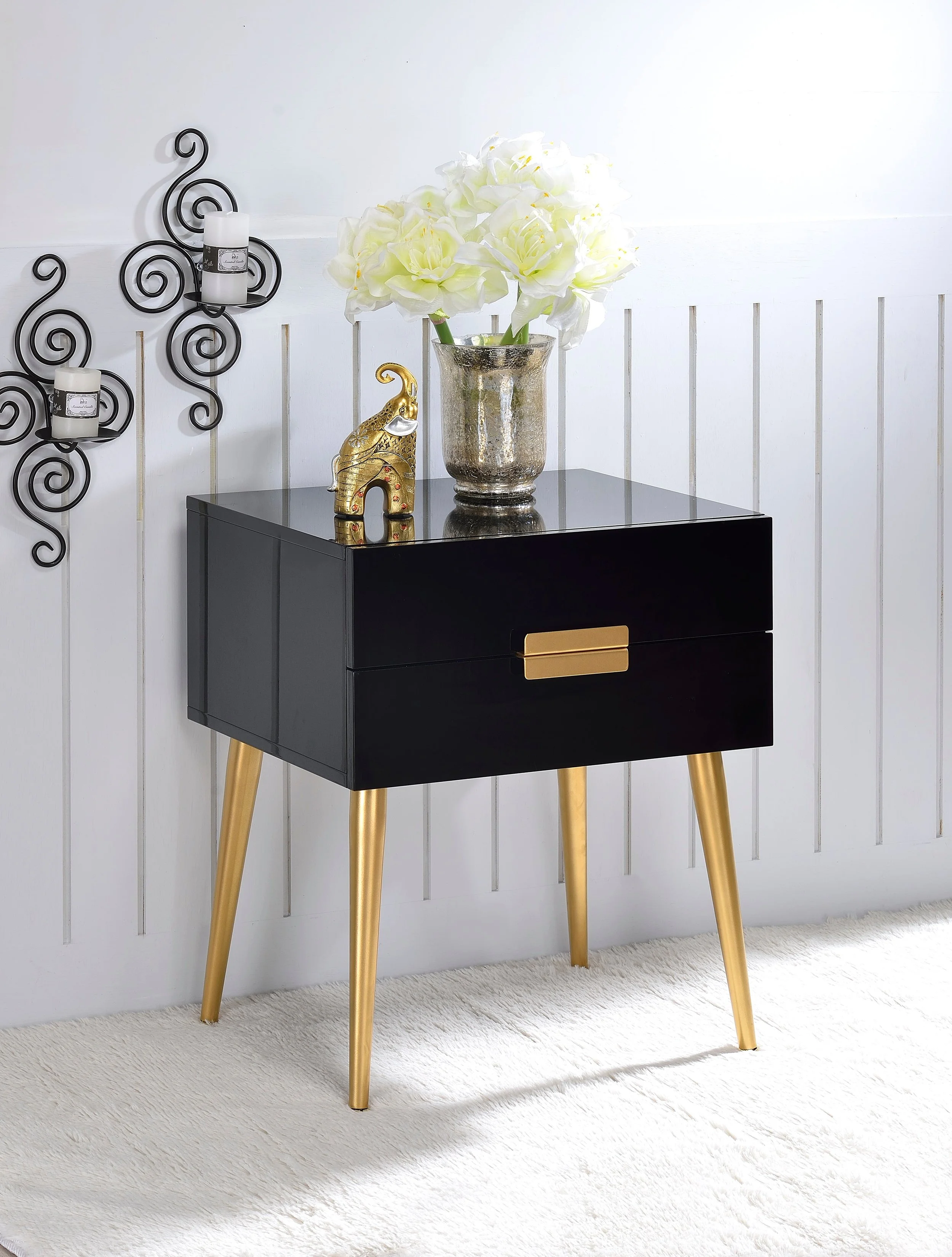 Denvor black and gold end table with decorative objects and flowers, shown in shop product styling.