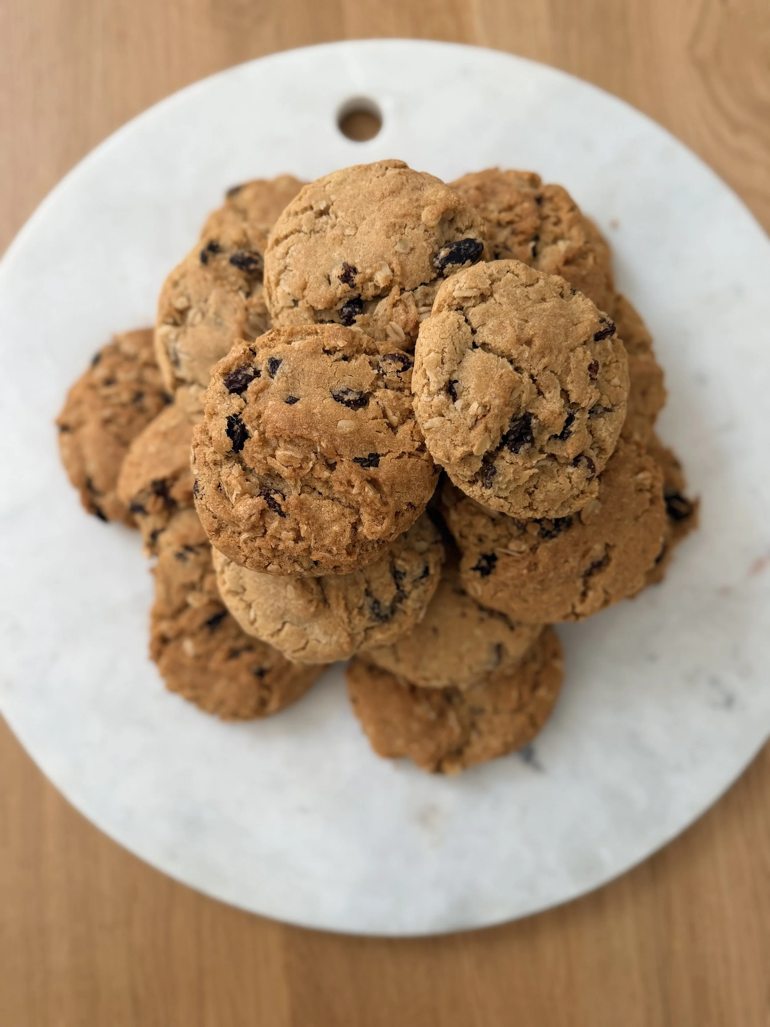 Close-up of several oatmeal cookies with chocolate chips on a white plate.
