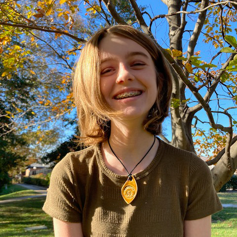 Ellie outside in front of a tree