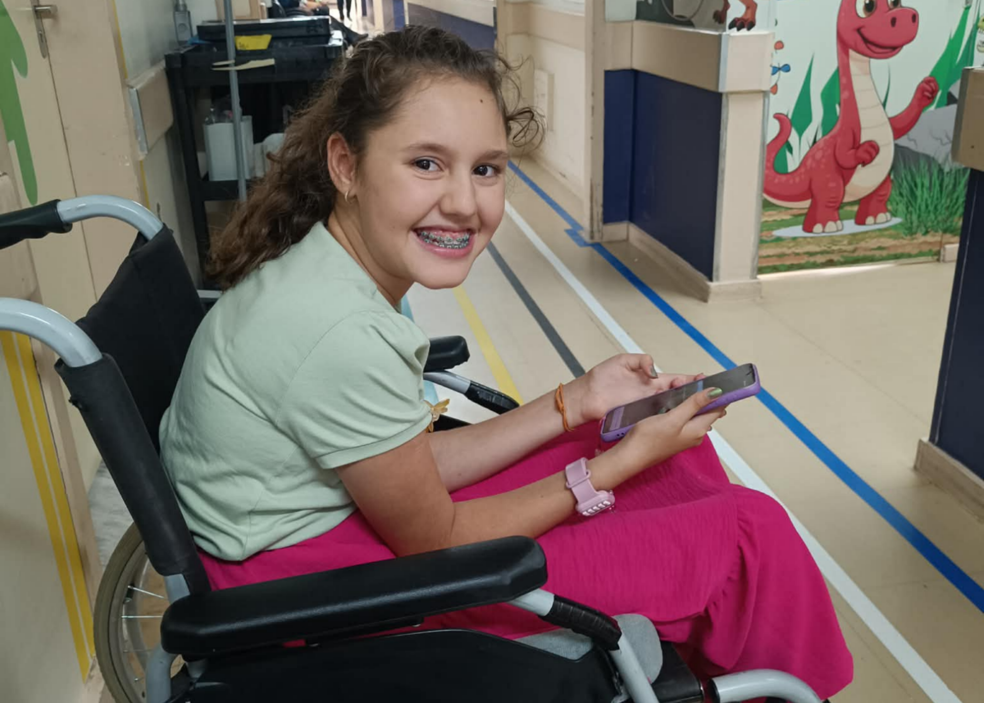 Alice in a wheelchair, holding a phone
