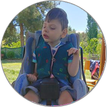 A boy with LBSL sitting outdoors