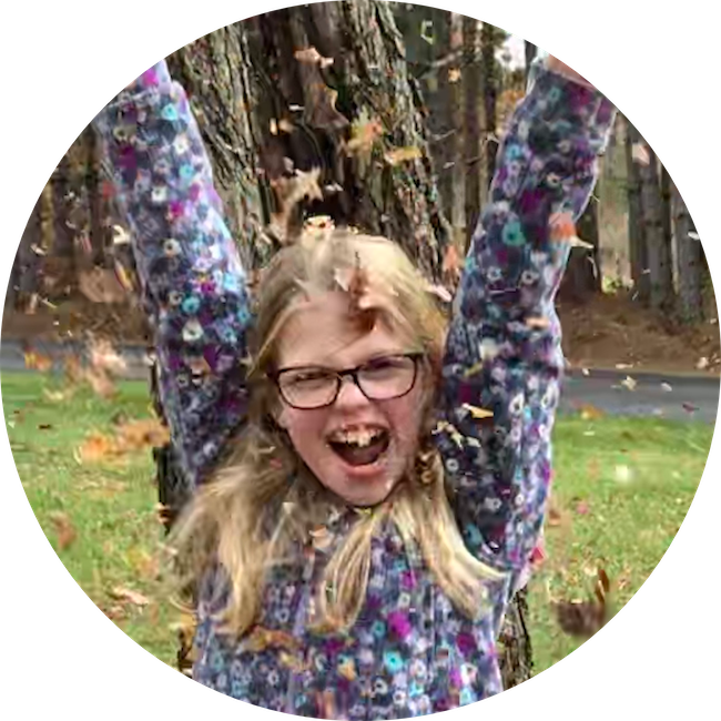A girl playing in fallen leaves