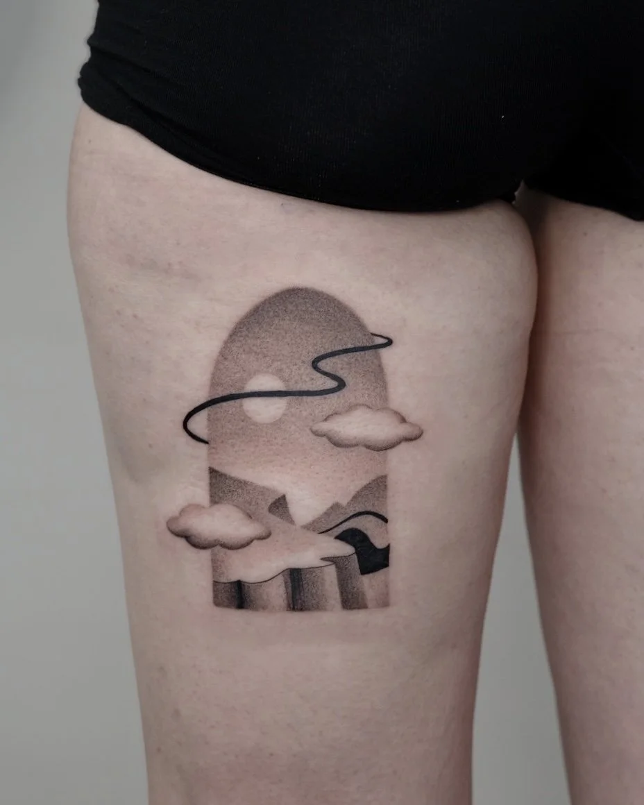 Tattoo of a stylized mountain landscape with clouds, a sun, and a winding line, within an oval outline, on a person's upper thigh.