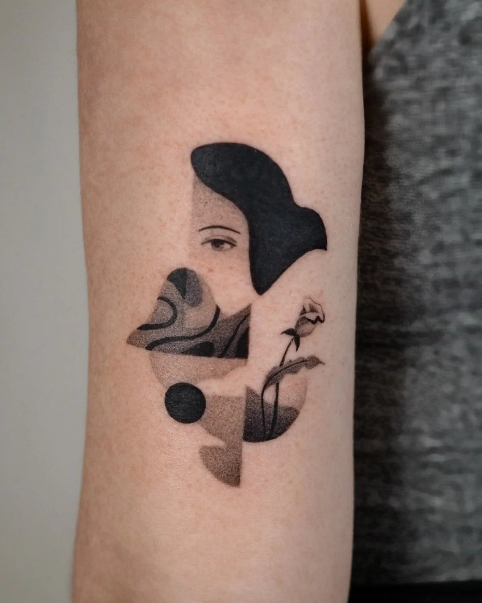 Tattoo of a woman's face integrated with a bird's silhouette, created with various shades of black and gray ink.
