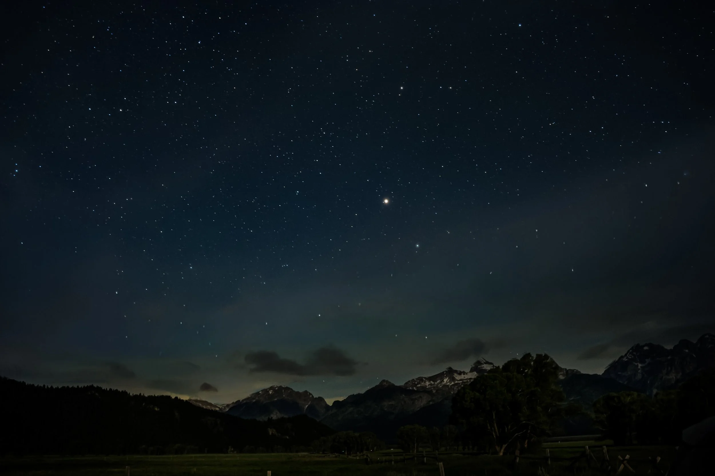 Star-filled night sky above the Teton Range in Grand Teton National Park after sunset.