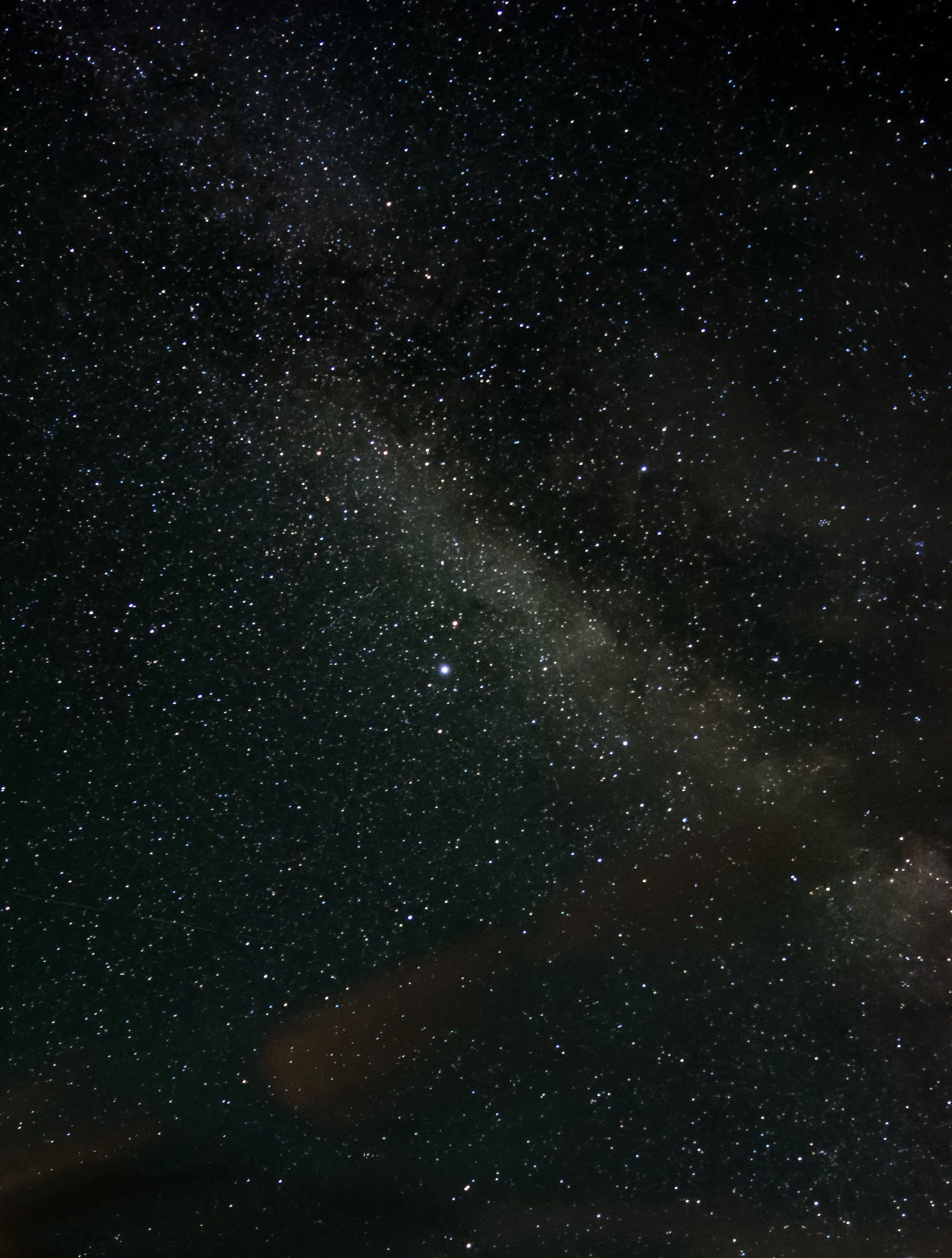 Milky Way stretching across the night sky above the mountains in Grand Teton National Park.