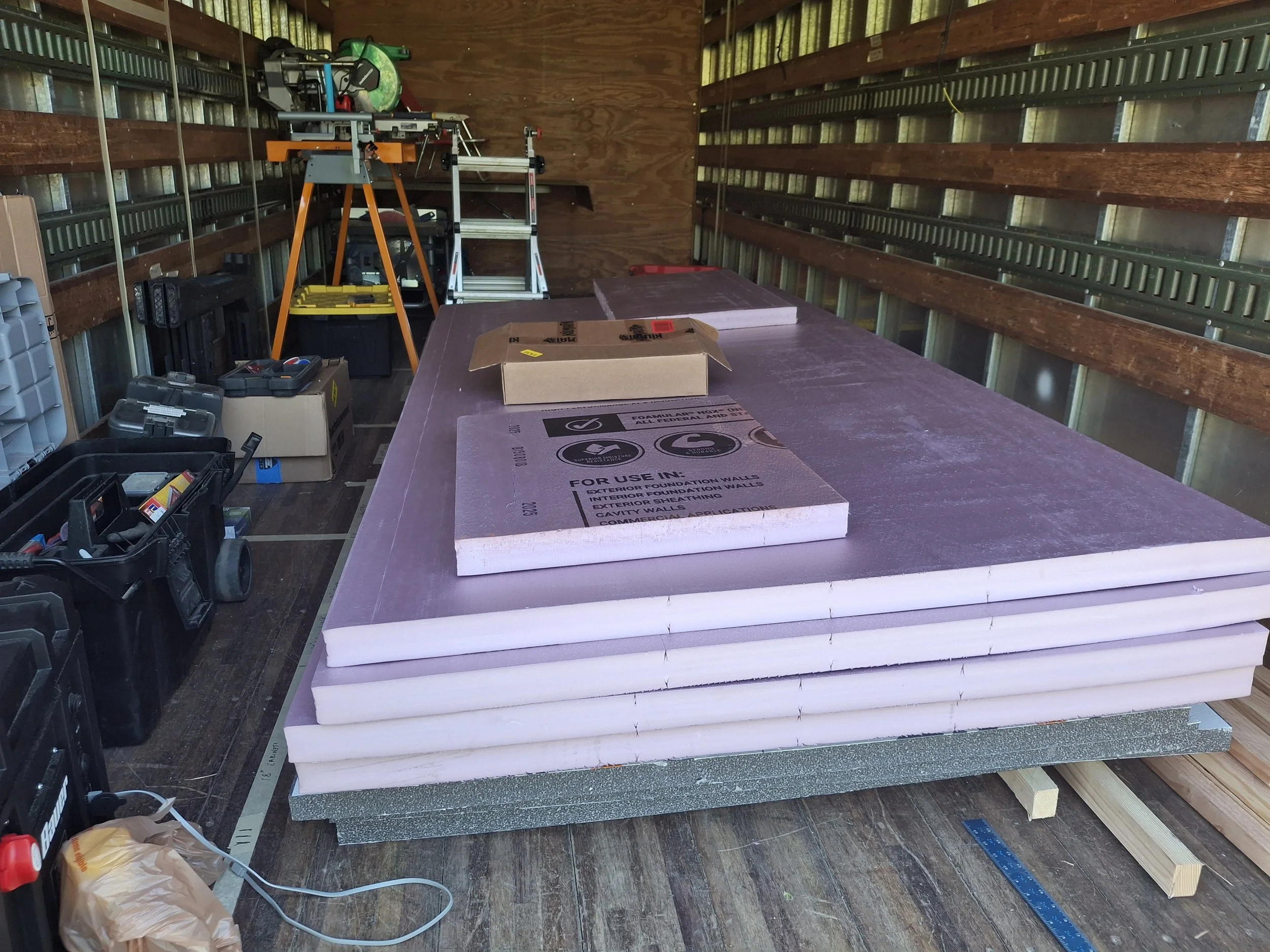 Rigid foam insulation prepared for installation during the DIY conversion of a commercial Isuzu NPR box truck into an off-grid RV, stealth camper, and mobile storytelling studio.