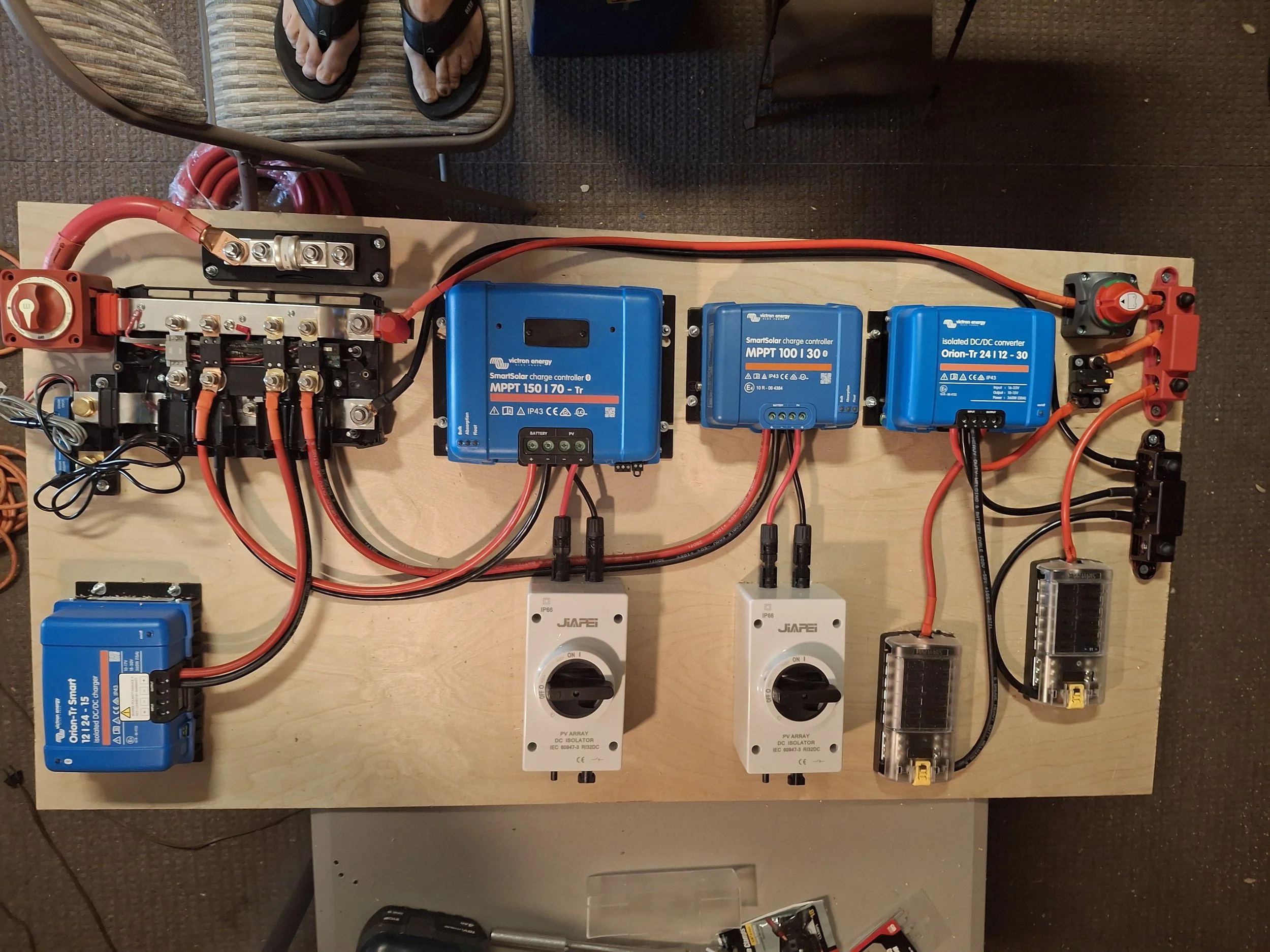 Custom electrical system featuring Victron Energy MPPT charge controllers, battery monitor, DC-DC charger, and power distribution for a 24-volt off-grid stealth RV and DIY truck camper conversion.
